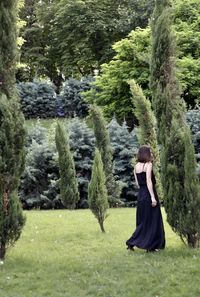 Woman standing by plants in forest