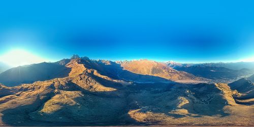 Aerial view of mountain range against blue sky