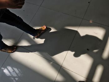 Low section of person standing on tiled floor