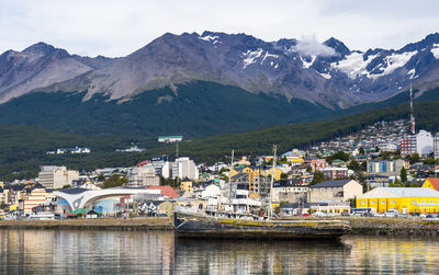 Scenic view of townscape and mountains against sky