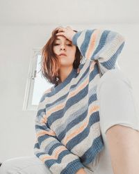 Beautiful young woman sitting at home