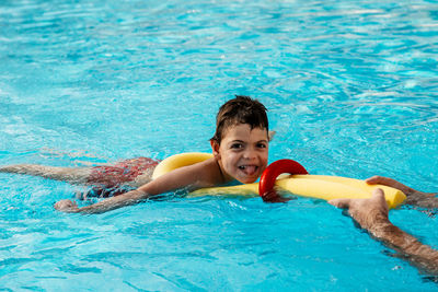 Portrait of smiling boy swimming in pool