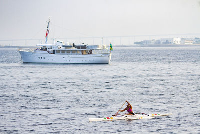 People on boat sailing in sea against sky