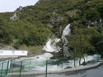 Scenic view of waterfall against mountains