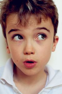 Close-up portrait of boy looking away by wall