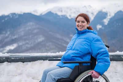 Portrait of smiling woman sitting on wheelchair