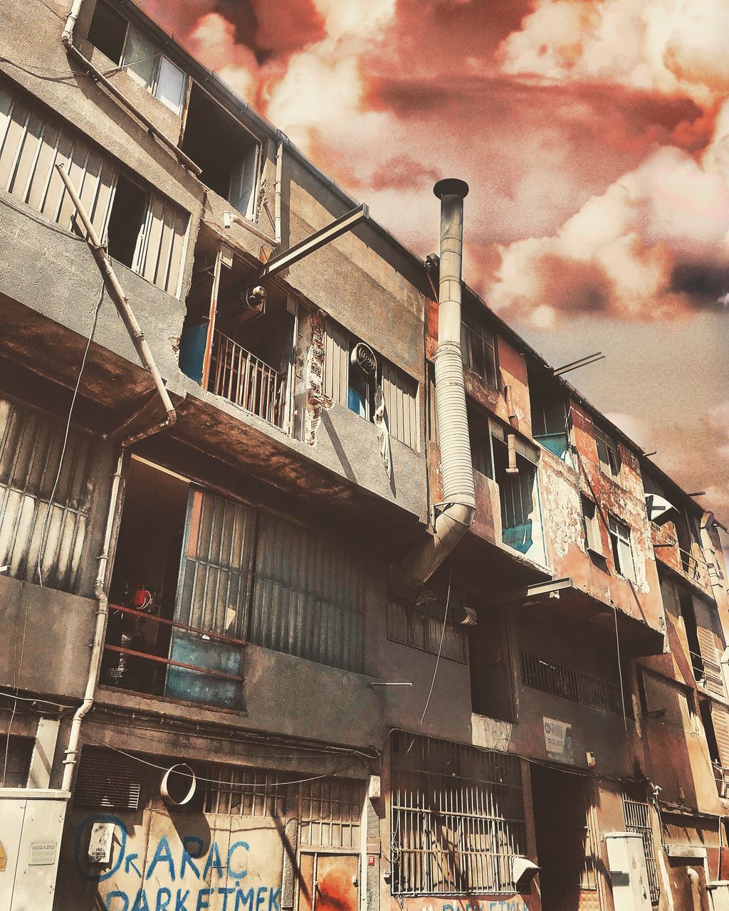 architecture, building exterior, built structure, cloud - sky, building, low angle view, residential district, no people, sky, nature, city, apartment, day, outdoors, industry, hanging, window, old, factory, balcony, pollution