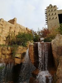 Low angle view of waterfall against sky