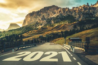 Road sign by mountain against sky