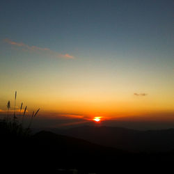 Scenic view of silhouette mountains against clear sky during sunset