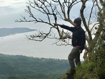 Man standing on tree against mountain