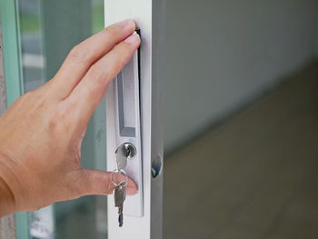 Close-up of hand fixing lock on glass door