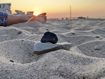 Shadow of person on sand at beach against sky during sunset