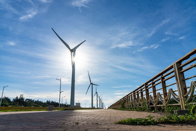 Wind turbines on land against sky