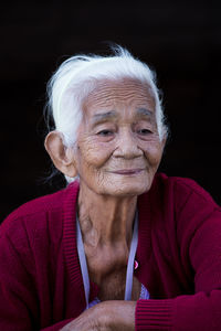 Portrait of smiling woman against black background