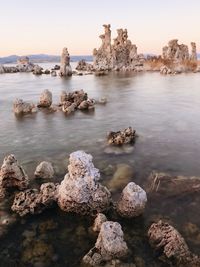 Rocks in sea against clear sky