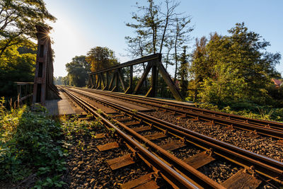 Railroad tracks by trees against sky