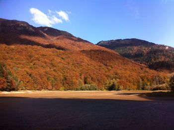 Scenic view of road by mountains against sky