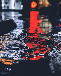 Close-up of wet road in city at night