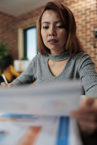 Portrait of young woman sitting on table