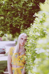 Midsection of woman standing against plants