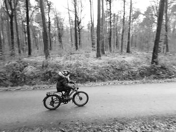 Man cycling on road in forest