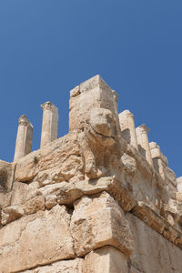 Low angle view of rock formations against clear blue sky