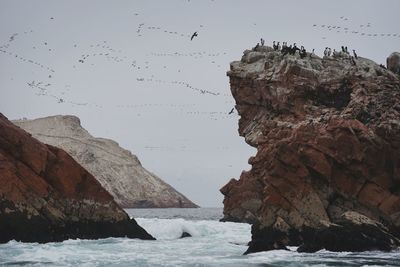 Scenic view of rock formation in sea against sky