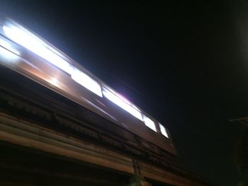 Low angle view of illuminated train against sky at night