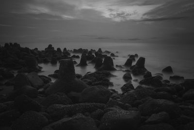 Rocks on beach against sky