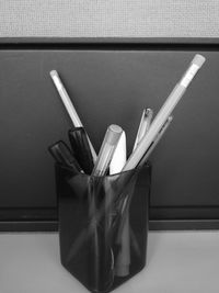 Close-up of paintbrushes in jar on table