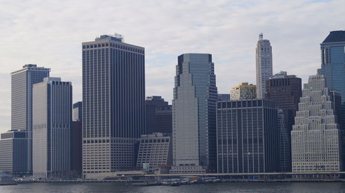 Skyscrapers at waterfront against sky