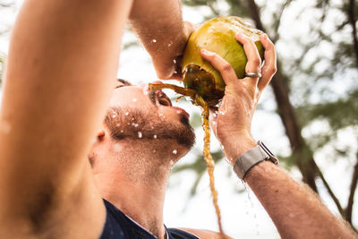 Close-up portrait of man holding ice cream cone outdoors