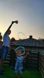 People playing soccer against sky during sunset