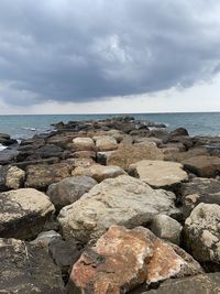 Rocks on sea shore against sky