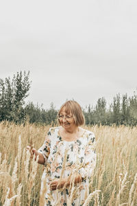 Woman standing on field against sky