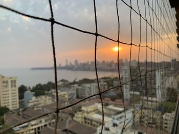 Buildings in city against sky during sunset