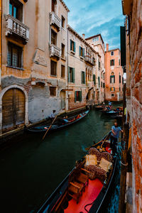 Typical venetian canal crowded with gondolas crossing it