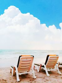 Chairs at beach against sky