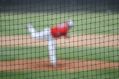 Close-up of sports net with baseball player playing in background