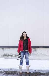 Portrait of smiling young woman standing in snow