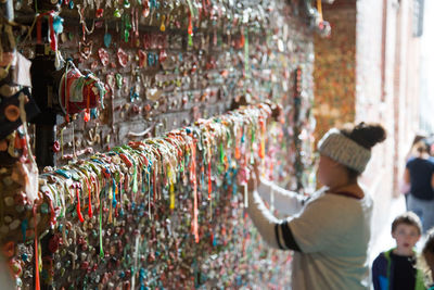 Side view of woman standing by gum wall