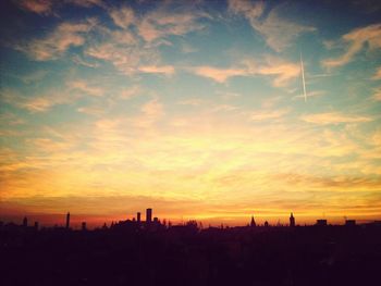 Silhouette cityscape against sky during sunset