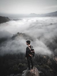 Man standing on rock against mountain range