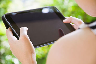 Cropped hands of woman using digital tablet