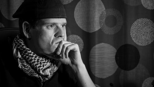 Close-up of thoughtful man wearing hat looking away at home