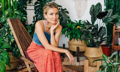 Portrait of a young attractive woman sitting in a chair in a flower studio.