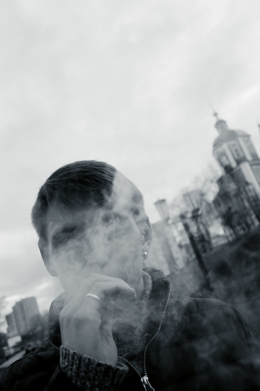 real people, one person, headshot, sky, social issues, lifestyles, portrait, smoking issues, bad habit, smoking - activity, cigarette, smoke - physical structure, activity, architecture, built structure, men, leisure activity, outdoors