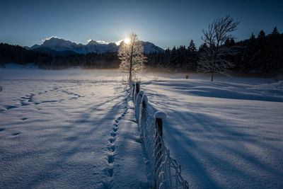 Frozen landscape against sky during winter