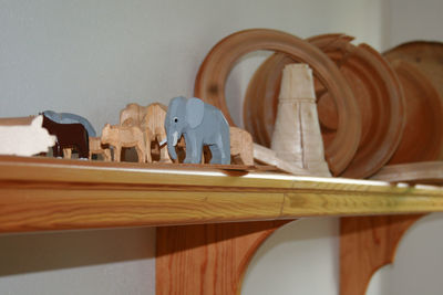Wooden figurines over shelf on wall